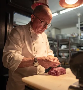 Le Chef Stéphane Avelin ficelle un filet de bœuf pendant un cours de cuisine